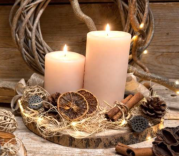 Centrotavola rotondo su piatto di legno con candele e addobbi naturali.